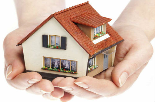 Hands holding a miniature house